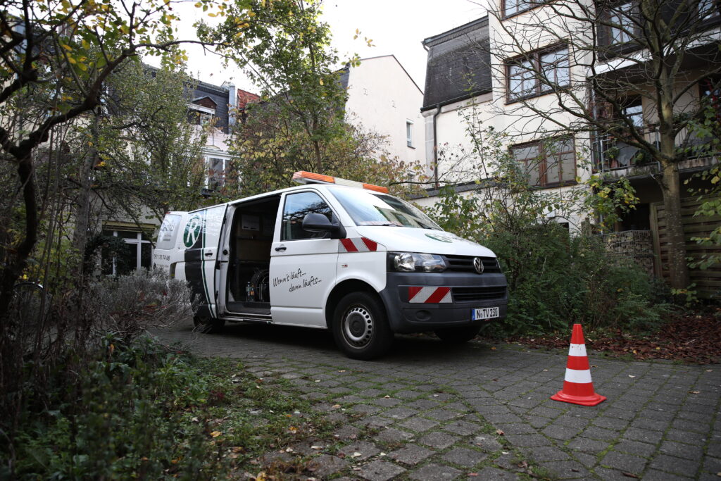 Servicefahrzeug von Rapid Rohr- und Kanaltechnik bei einer geplanten Wartung einer Entwässerungsanlage an einem Mehrfamilienhaus.